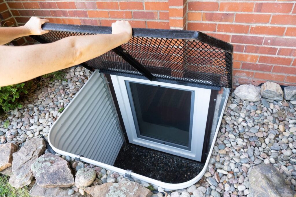 Basement egress window well with protective metal safety cover