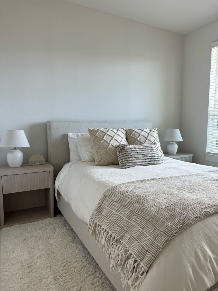 Minimalist neutral bedroom with beige bedding and soft textured pillows