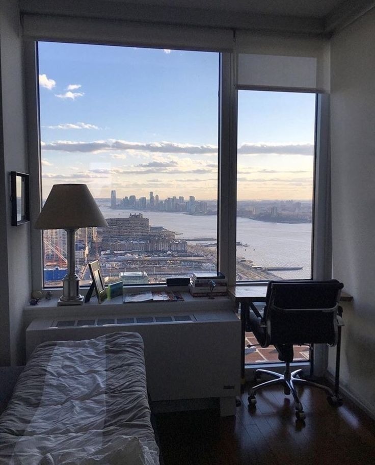 High-rise bedroom with panoramic river and city skyline view
