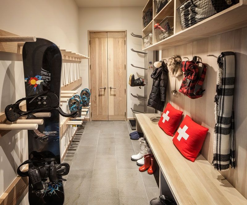 Ski room with organized snowboard storage and winter gear hooks