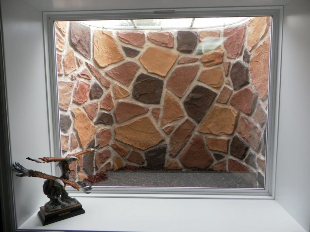 Basement window looking into stone wall window well